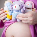 teddy bears sitting on pregnant belly