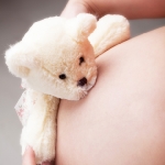 Teddy bear hugs pregnant belly
